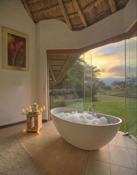 Baño con tina de hidromasaje y vista panorámica al paisaje.