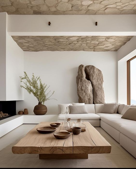 Sala de estar con decoración minimalista, techo de piedra y mesa de madera maciza.