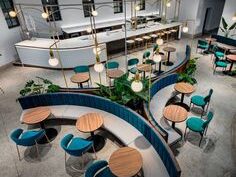 Vista aérea de un restaurante moderno con asientos curvos y decoración minimalista.